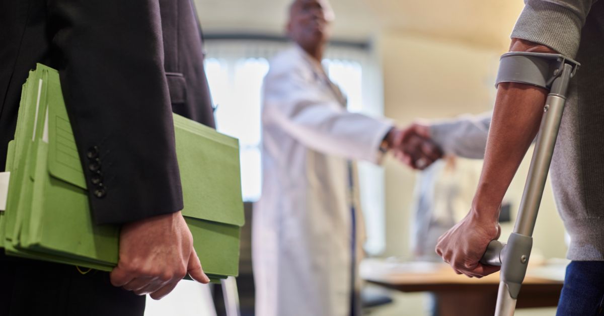 attorney and man in brace talking to doctor